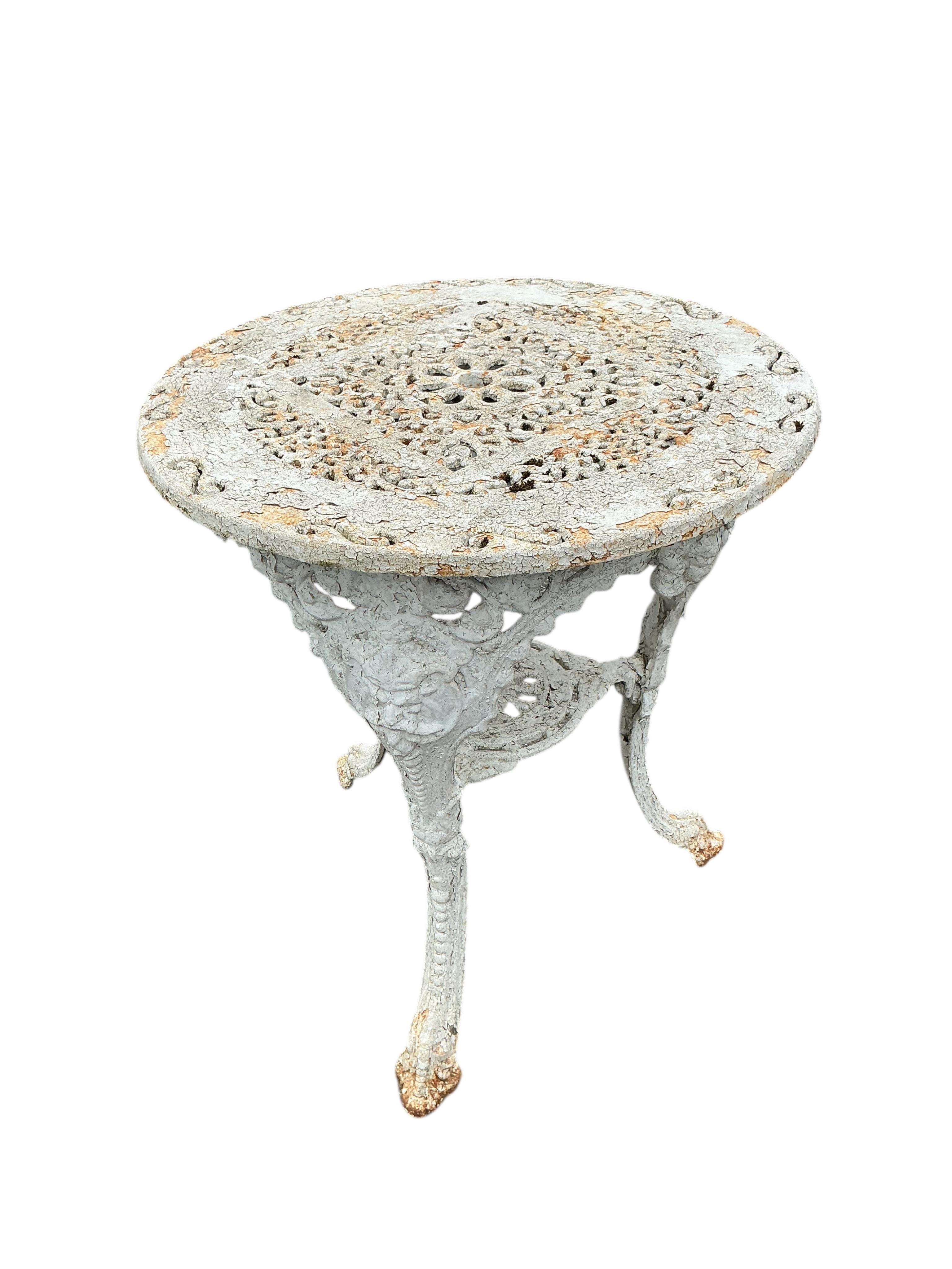 A Victorian Coalbrookdale style later painted circular cast iron garden table, diameter 61cm, height 70cm together with two later chairs